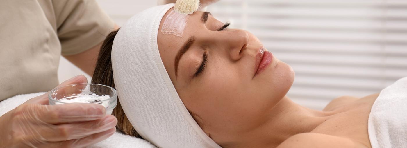 Application d'un peeling professionnel au pinceau — soin du visage en clinique